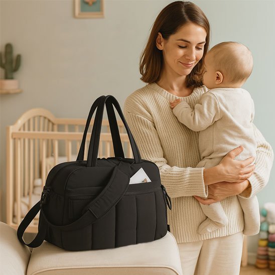 bebe dans les bras de maman à coté du Sac a langer