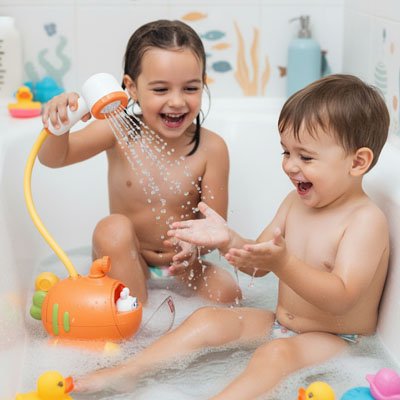 petit fille arrose son petit frère avec jouet de bain bébé   