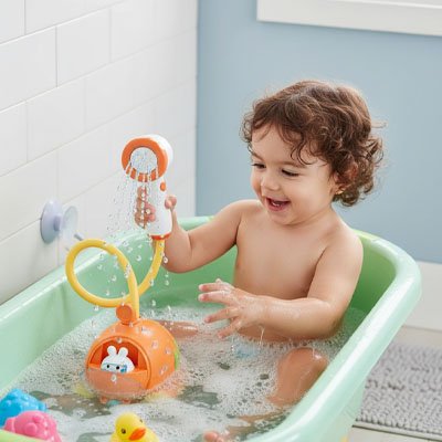 petite fille dans son bain qui joue avec jouet de bain bébé   